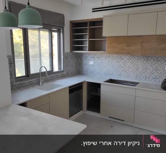 מטבח עם משטחי עבודה נקיים וכיור ריק